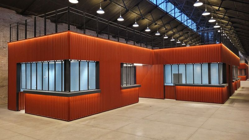 Interior, shipping containers combined to form retail spaces within the restored warehouse.